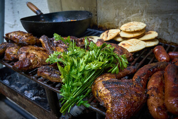 A plate of food with chicken, arepa and vegetables on a grill