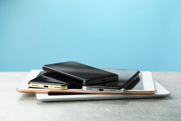 Stack of electronic devices on grey table, closeup
