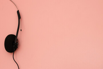 A pair of 1990's style headphones on a pink background retro vintage music concept image