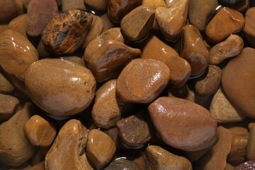 Beautiful pebbles in water as background, top view