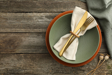 Stylish setting with cutlery, bowl and plate on wooden table, top view. Space for text