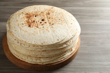 Many tasty homemade tortillas on wooden table