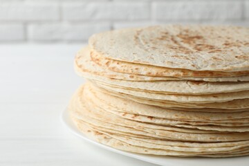 Stack of tasty homemade tortillas on white table