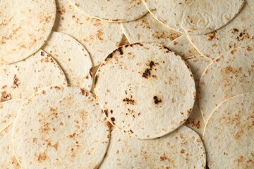 Many tasty homemade tortillas as background, top view