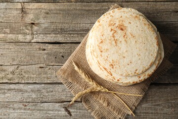 Tasty homemade tortillas and spikes on wooden table, top view. Space for text
