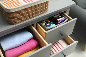 Chest of drawers with different folded clothes indoors, above view