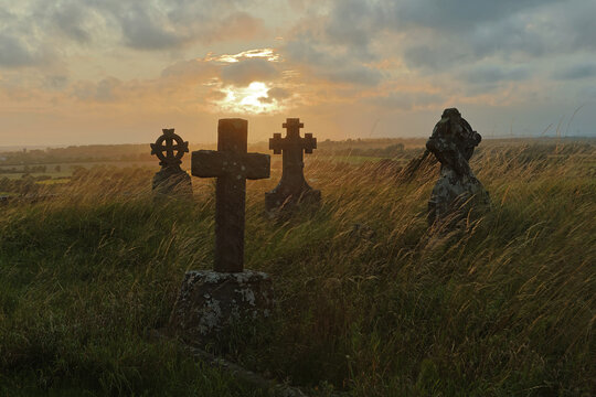 Gravestones at sunset with a dramatic cloudy sky - Powered by Adobe