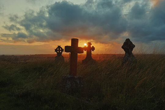 Gravestones at sunset with a dramatic cloudy sky