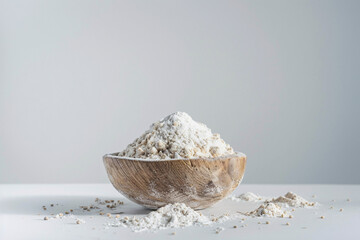 Wooden bowl filled with flour on a clean white background