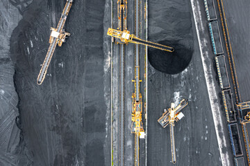 Aerial view of excavator and conveyor belt in coal storage. Coal transport and large warehouse