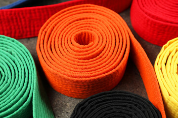 Colorful karate belts, closeup. Martial arts uniform