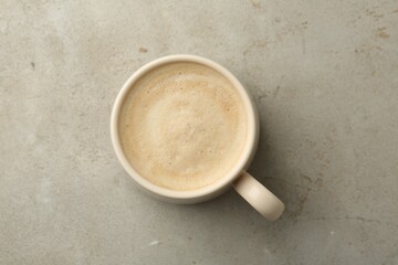 Cup of aromatic coffee on grey table, top view