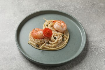 Heart made of tasty spaghetti, tomato, shrimps and cheese on light grey table