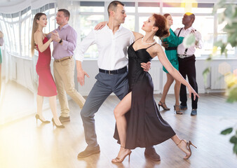 Dance training in group - men and women of different nationalities and different ages dance tango...