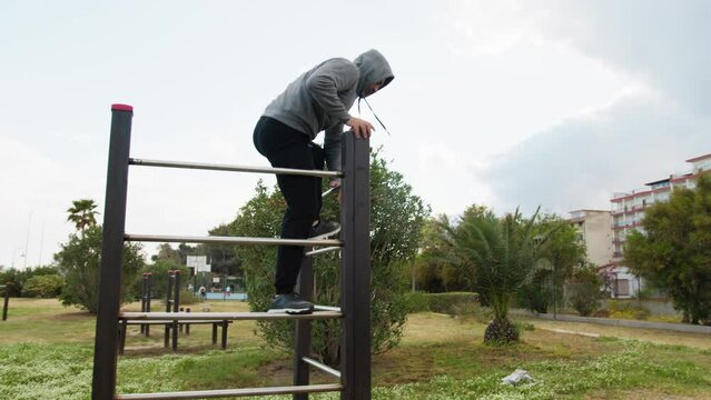 Man With Gray Hood Jumps And Does Somersault For Intensity Training