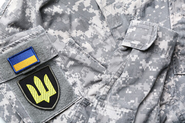 Badges with trident and flag of Ukraine on military uniform, closeup