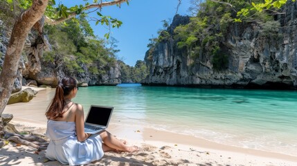 Serene beach scene  woman in elegant white attire working remotely on laptop at peaceful seaside