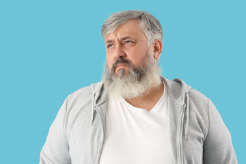 Portrait of sad senior man on blue background