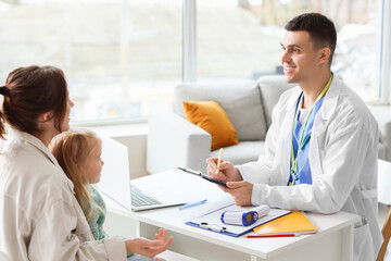 Fototapeta premium Mother with little girl on appointment to male pediatrician in clinic