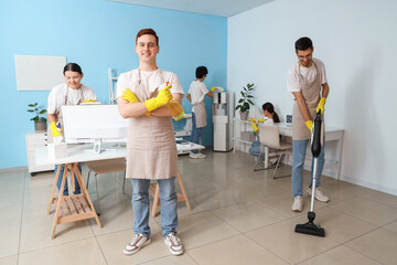 Group of young janitors cleaning in office