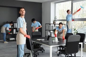 Team of janitors cleaning in office