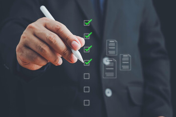 Electronic smart checklist and document on virtual screens concept, Businessman use pen to tick correct sign mark in checkbox for quality document control checklist and business approve concept.