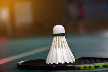 Badminton sport equipments, rackets and shuttlecocks on dark floor of indoor badminton court, soft...