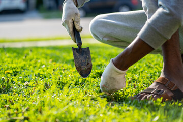 image of a cropped african man with a garden tool, black guy working on a greenfield.