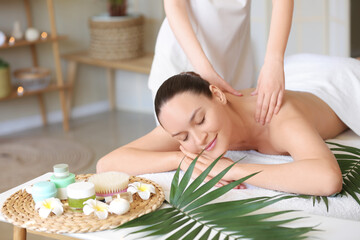 Obraz na płótnie Canvas Young woman getting shoulders massage in spa salon