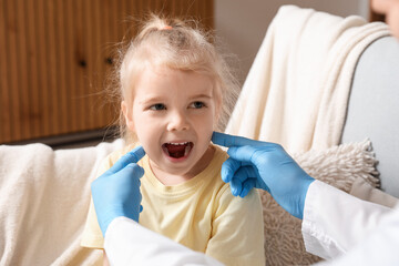Pediatrician examining little girl at home, closeup