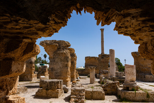 Partially reconstructed Baths of Carthage, largest complex of Roman thermae on African continent, with remains of stone walls and Corinthian columns giving sense of former grandeur under Tunisian sun