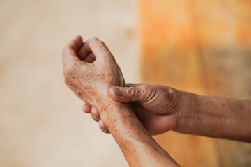 Senior woman holding his painful wrist.