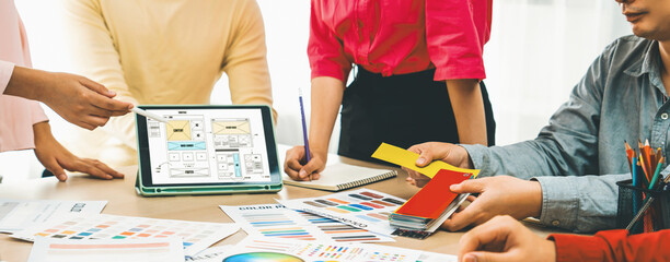 Cropped image of interior designer team discuss the material color while tablet displayed website...