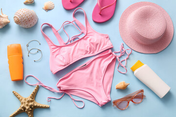 Composition with stylish female swimsuit, beach accessories and seashells on color background