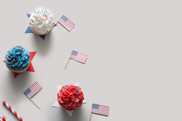 Tasty patriotic cupcakes with USA flags and stars on grey background. American Independence Day