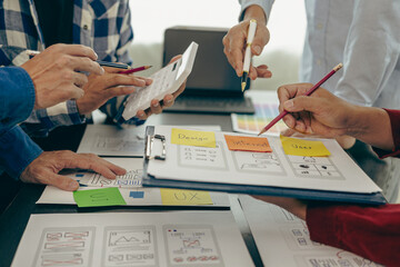 A team of UX designers works on a new website layout. Plan mobile web application development in...