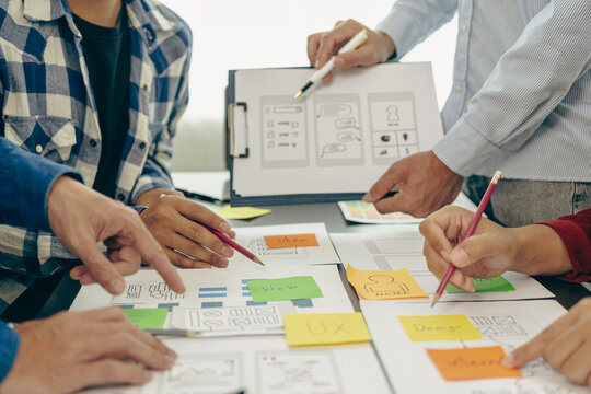 A team of UX designers works on a new website layout. Plan mobile web application development in prototyping. Developing products and adding new ideas, close-up shots