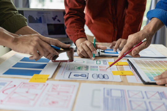 A team of UX designers works on a new website layout. Plan mobile web application development in prototyping. Developing products and adding new ideas, close-up shots
