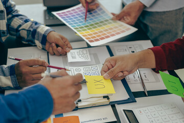 A team of UX designers works on a new website layout. Plan mobile web application development in...