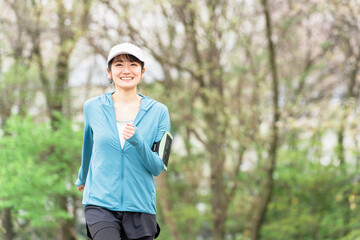 健康・美容・ダイエットのために公園をウォーキング・ジョギングする若いアジア人女性
