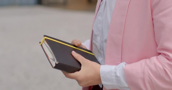 Woman realtor talking to client, close-up of hands with notebook. Concept of property consultation, real estate agent, professional communication. 