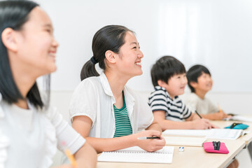 塾・学校で笑顔で授業を受ける小学生・中学生の女の子・男女
