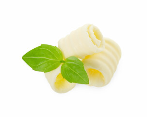 Tasty butter curls and basil leaves isolated on white