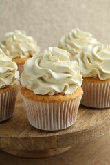 Tasty vanilla cupcakes with cream on table, closeup