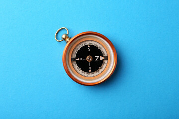 One compass on light blue background, top view