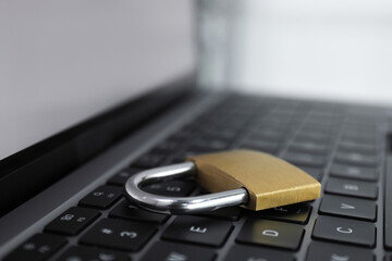 Cyber security. Metal padlock on laptop, closeup