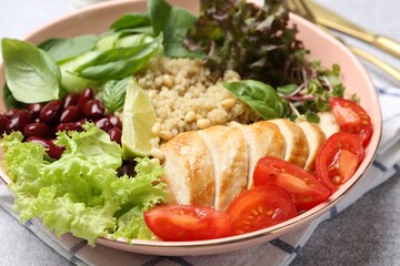 Healthy meal. Tasty vegetables, quinoa and chicken breast in bowl on white table, closeup