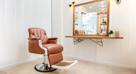 Fototapeta premium Brown leather barber's chair in a traditional barbershop. Brightly lit, with mirror.