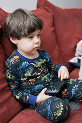 cute boy with a game pad playing on the couch