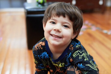 Expressive young boy in pajamas making faces